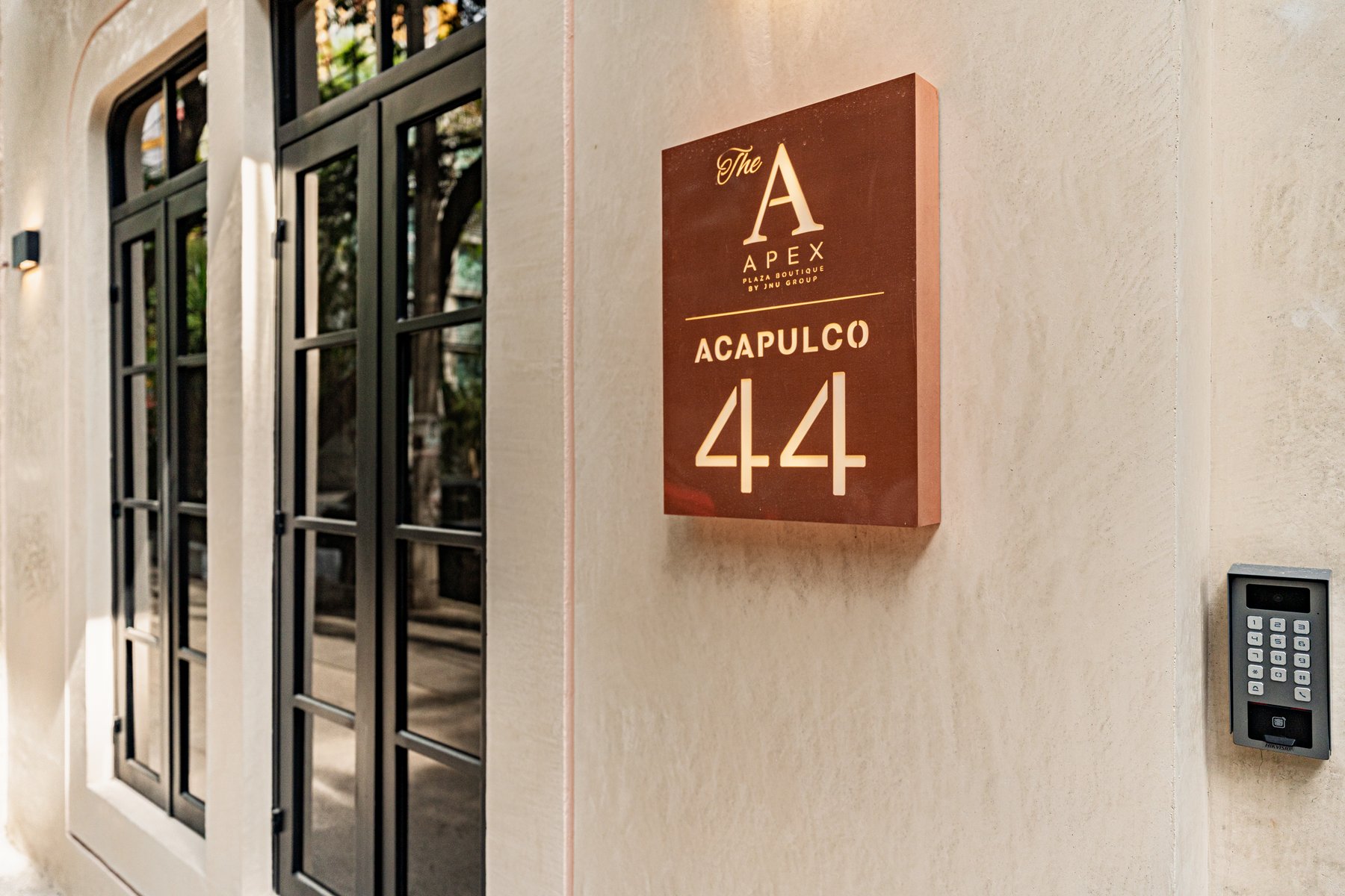 Fachada de Acapulco 44 con árbol y placa Apex
